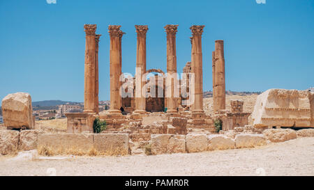 old ancient Greco-Roman columns line cobblestone streets on a warm summers day in Jerash, Jordan Stock Photo