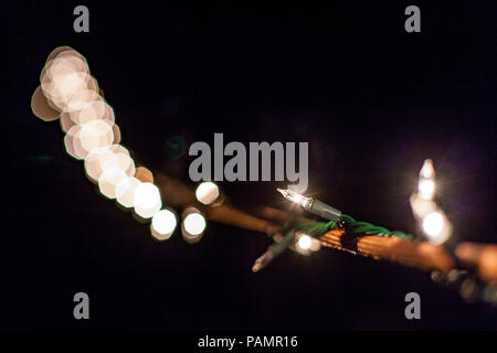 Night picture of outdoors christmas lights twirled around a climbing rope with abstract bokeh background Stock Photo
