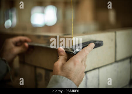 Brickmason using a square to build a brick wall Stock Photo