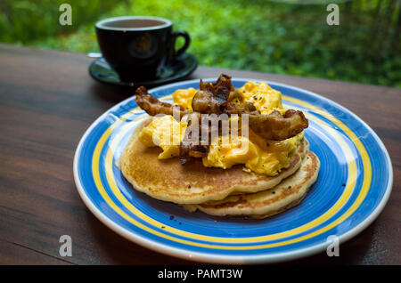 Pancake sandwich with bacon and scrambled eggs on top. Stock Photo