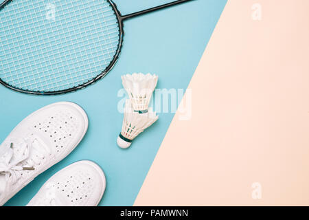 Shuttlecock and badminton racket with sport shoes on pastel color background Stock Photo