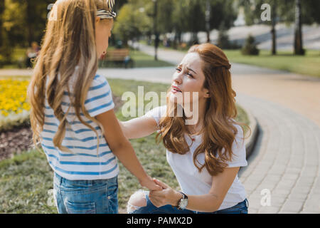 Beautiful mother feeling worried while taking her daughter to school Stock Photo