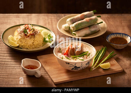 Assorted asian dinner, vietnamese food. Chicken rice, bun cha ca, noodles, spring rolls Stock Photo