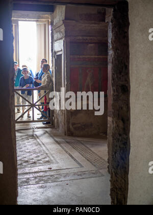 Tourists in the Villa of the Mysteries, a preserved Roman Villa in Pompeii, a once wealthy city buried by the eruption of Mount Vesuvius in 79 AD. Stock Photo