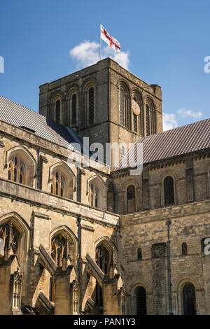 Winchester Cathedral from within the grounds looking up at the St Georges Cross flag of England on top of the tower. Stock Photo