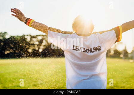 Cheering boy wearing football shirt with Germany written on back Stock Photo