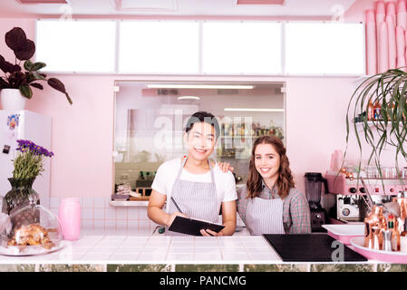 Two young smiling waiters preparing for workday Stock Photo