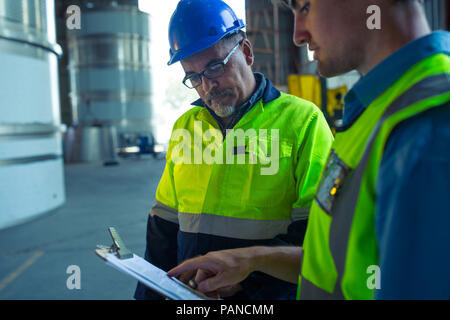 Engineers in industrial plant discussing work Stock Photo