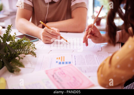 Two students holding pencils in their hands studying mathematics Stock Photo
