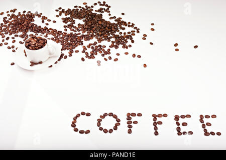 Line of coffee beans with Mug filled with coffee beans and an inscription from coffee beans Stock Photo