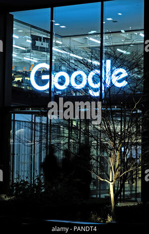 The entrance to Google's new UK headquarters building in St Pancras Square, London with  Google sign above door. Night time, portrait. Stock Photo