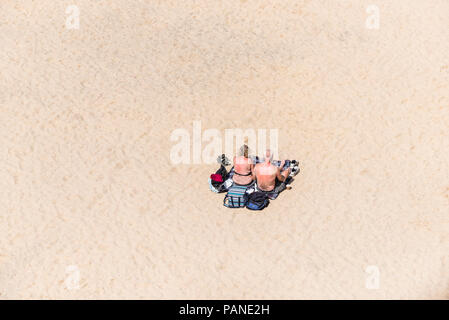 A mature couple holidaymakers visitors sunbathing on a beach in Newquay in Cornwall. Stock Photo