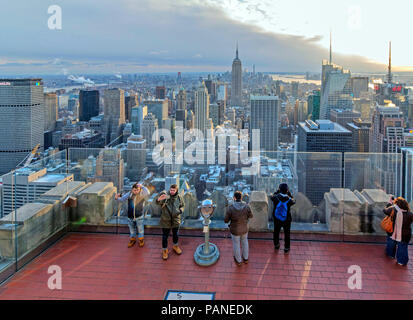 Tourists enjoy a panoramic view of Manhattan from viewing platform at the top of the Rockefeller Centre (Top of the Rocks) , New York City, USA , Dece Stock Photo