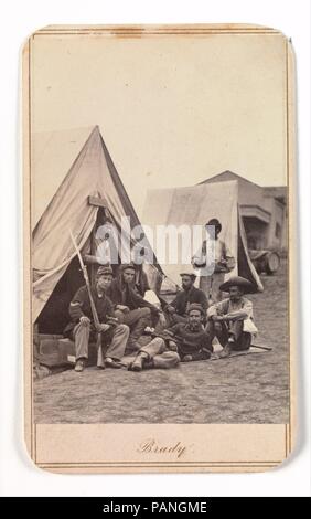 [Camp Scene with Soldiers of the 22nd New York State Militia, Harper's Ferry, Virginia]. Artist: Mathew B. Brady (American, born Ireland, 1823?-1896 New York). Dimensions: Image: 8.7 x 5.8 cm (3 7/16 x 2 5/16 in.)  Mount: 10.2 x 6.1 cm (4 x 2 3/8 in.). Date: 1862.  In fall 1862 Brady made a rare group of carte-de-visite studies of the Twenty-second New York State Militia outdoors at Harpers Ferry. These portraits--as much like traditional genre scenes as any produced during the war--are among the most carefully composed extant field photographs. Almost all feature soldiers conversing, playing  Stock Photo