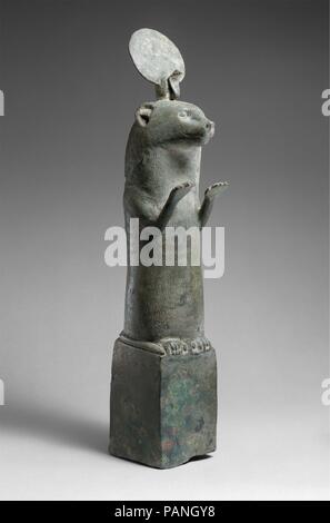 Otter statue. Dimensions: H. 45.5 cm (17 15/16 in.); W. 8.3 cm (3 1/4 in.); D. 12.4 cm (4 7/8 in.). Date: 664-30 B.C..  During the Late Period and Ptolemaic times otters were represented in bronzes statuettes such as this one, standing, forepaws raised, atop small bronze boxes. The pose of raised paws signifies the otter's adoration of the sun god when he rises in the morning.  In myth otters were attached to the goddess of Lower Egypt Wadjet, whose cult was centered in Buto, in the northern Delta. Museum: Metropolitan Museum of Art, New York, USA. Stock Photo