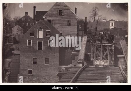 End of the Bridge after Burnside's Attack, Fredericksburg, Virginia. Artist: Andrew Joseph Russell (American, 1830-1902). Dimensions: Image: 13.1 × 20.6 cm (5 3/16 × 8 1/8 in.). Former Attribution: Formerly attributed to Mathew B. Brady (American, born Ireland, 1823?-1896 New York). Date: 1863.  Likely made in April 1863 during a truce just before the Battle of Chancellorsville, this view from the buttress of a ruined railroad bridge spanning the Rappahannock River at Fredericksburg documents a small group of Confederate soldiers and civilians. They stare across the divide at their fellow comb Stock Photo