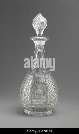 Decanter. Culture: American. Dimensions: H with stopper: 12 1/4 in. (31.1 cm), without stopper: 9 1/4 in. (23.5 cm). Maker: Brooklyn Flint Glass Company (American, Brooklyn, New York, 1824-1868). Date: ca. 1855.  This decanter is from the same larger luxury glass table service as a compote and three drinking vessels in the collection (69.257, 2015.459.2-.4).  The decanter bears an engraved gothic-style 'H' in a carved shield on one of the alternating clear vertical panels. The service descended in the family of Johns Hopkins (1795-1873), prominent businessman, entrepreneur, abolitionist, and   Stock Photo