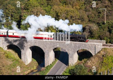 BR Standard Class 4 80104 steam locomotive running on a bridge at Corfe Castle on the heritage Swanage railway line - a popular tourist attraction, UK Stock Photo