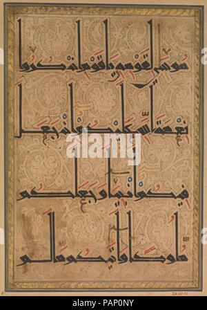 Folio from a Qur'an Manuscript. Dimensions: 11.75 in. high 8.75 in. wide (29.8 cm high 22.2 cm wide). Date: ca. 1180.  Written in Eastern or new style kufic script , line two of  this folio includes two long, vertical letters (alif and lam), forming a distinctive pointed oval-shaped pattern. The elaborate treatment of the background, entirely filled with vegetal scrolls terminating in large blossoms so that the script seems to stand out against the decorative background. The script and illumination are related to a Qur'an in the Topkapi Saray Museum, dated 573/1177-78, epigraphic inscriptions  Stock Photo