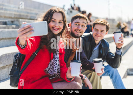 Russia, Moscow, group of friends taking a selfie and showing their cups of coffee Stock Photo