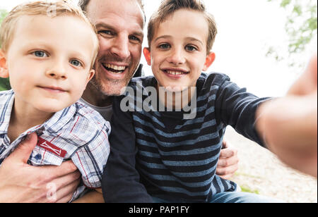 Selfie of happy father with two sons outdoors Stock Photo