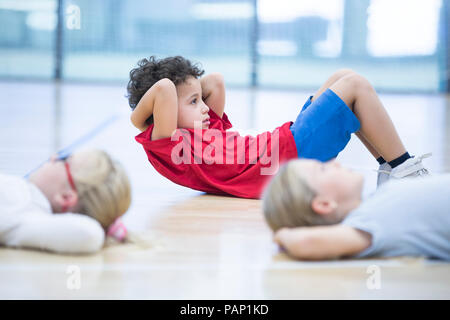 Pupils exercising in gym class Stock Photo