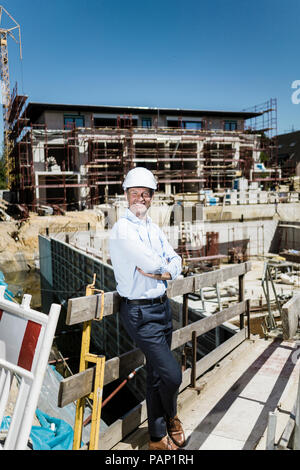 Portrait of smiling man wearing hard hat on construction site Stock Photo