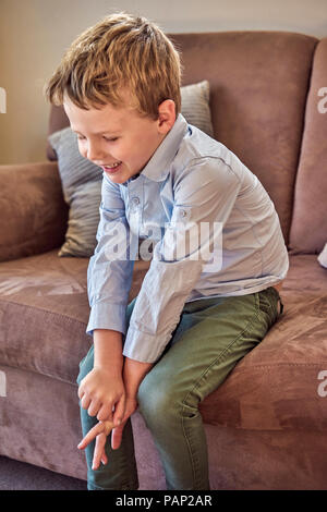 Happy boy sitting on couch Stock Photo