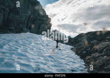 Norway, Lofoten, Moskenesoy, Young man hiking in the mountains Stock Photo