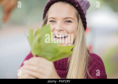 Portrait of happy teenage girl holding leaf Stock Photo