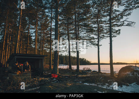 Sweden, Sodermanland, two men resting at lake Navsjon in winter Stock Photo