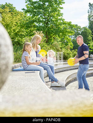 Happy family playing together in a park Stock Photo