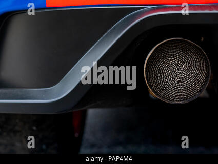 Close up detail exhaust pipe of blue SUV car. Unique pattern of car exhaust pipe. Accessories for sports car. Black soot on old exhaust pipe of gasoli Stock Photo