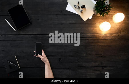 Person using smartphone at desk Stock Photo