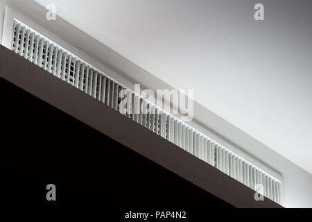 Modern ventilator of air conditioner in seminar room at the hotel. Air conditioning vent on ceiling. Air ventilation grid install on white concrete wa Stock Photo