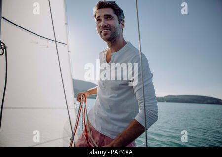 Smiling man standing on a sailing boat Stock Photo