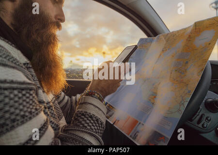 Man using smartphone in car, looking at map for directions Stock Photo