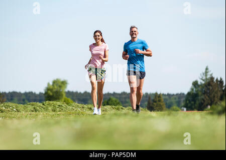 Couple running on field path Stock Photo