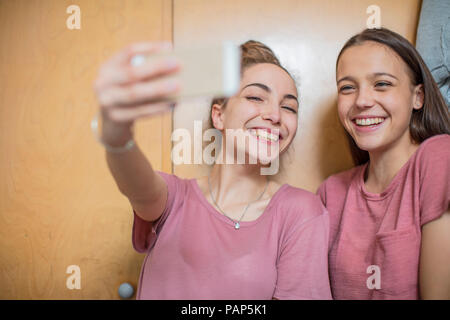 Portrait of two happy teenage girls taking a selfie Stock Photo