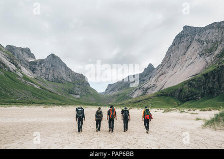 Norway, Lofoten, Moskenesoy, Young men hiking to Horseid Beach Stock Photo