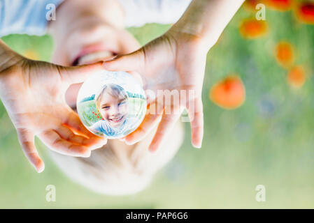 Boy holding tansparent sphere in poppy field Stock Photo - Alamy