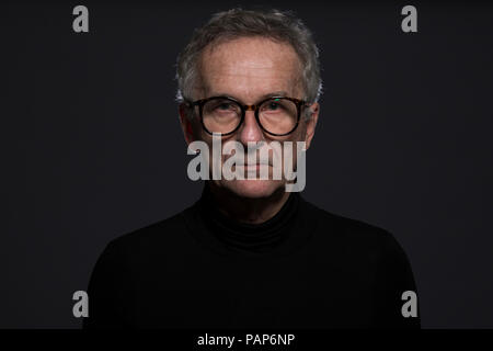 Portrait of serious senior man wearing glasses in front of dark background Stock Photo