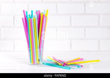 Multicolor cocktail tubes in a grass on white background. Close up. Copy space Stock Photo