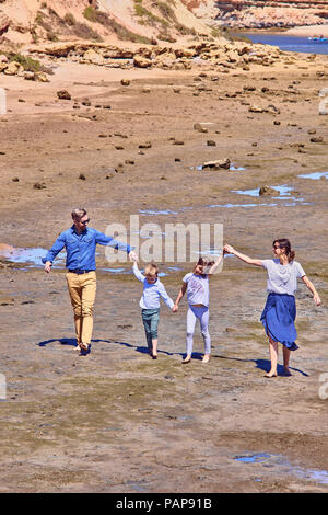 Australia, Adelaide, Onkaparinga River, happy family walking together hands in hands at beach Stock Photo