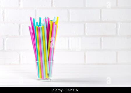 Multicolor cocktail tubes in a grass on white background. Close up. Copy space Stock Photo