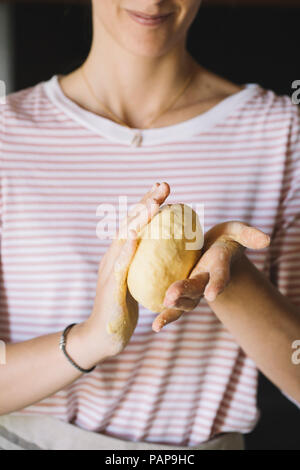 Woman kneading pasta dough in hands Stock Photo