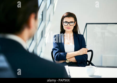 Portrait of confident businesswoman with businessman in modern office Stock Photo