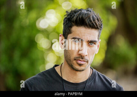 Portrait of sceptical young man in nature Stock Photo