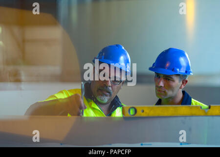 Engineers in industrial plant discussing work Stock Photo