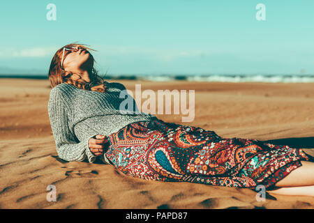 Young woman lying in desert landscape Stock Photo